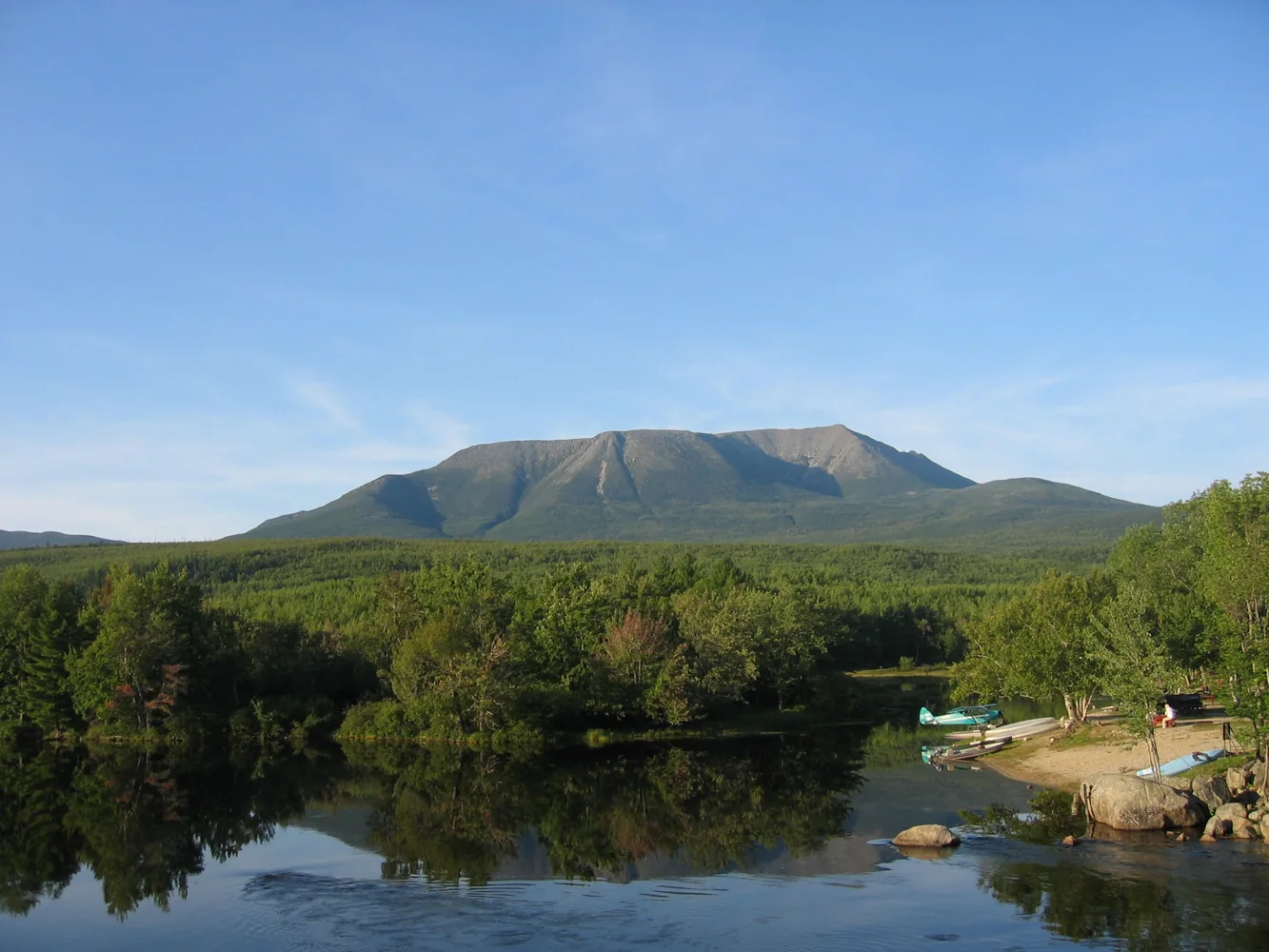 Katahdin rising above forest and a river, viewed from Abol Bridge in Maine.